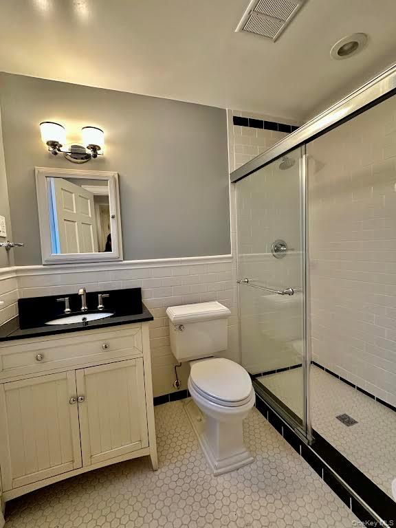 87 Franklin Avenue, Unit 1 New Rochelle, NY 10801 - Photo 7 of 11 Bathroom featuring a shower stall, vanity, wainscoting, and tile walls