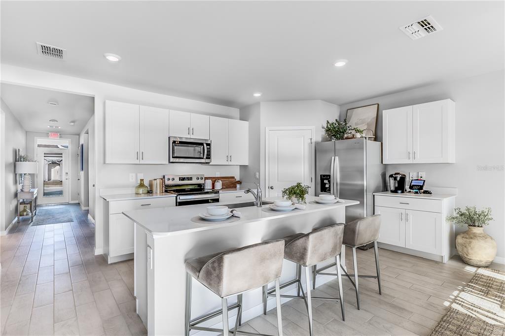9489 Turtle Grass Circle Punta Gorda, FL 33950 - Photo 3 of 19 a kitchen with white cabinets and stainless steel appliances