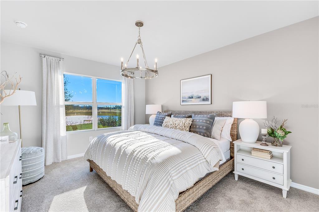 9489 Turtle Grass Circle Punta Gorda, FL 33950 - Photo 9 of 19 a bedroom with a large bed and a chandelier