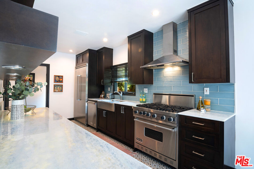 6331 Drexel Avenue Los Angeles, CA 90048 - Photo 19 of 37 a kitchen with stainless steel appliances granite countertop a stove a sink and a refrigerator