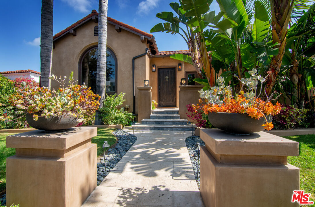 6331 Drexel Avenue Los Angeles, CA 90048 - Photo 4 of 37 a front view of a house with lots of flowers and trees