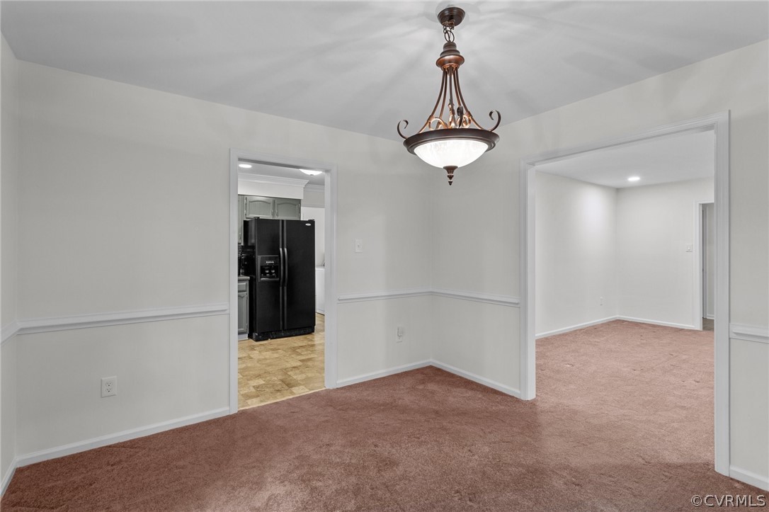 8601 Beaver Bridge Road Moseley, VA 23120 - Photo 16 of 42 an empty room with chandelier fan and kitchen view