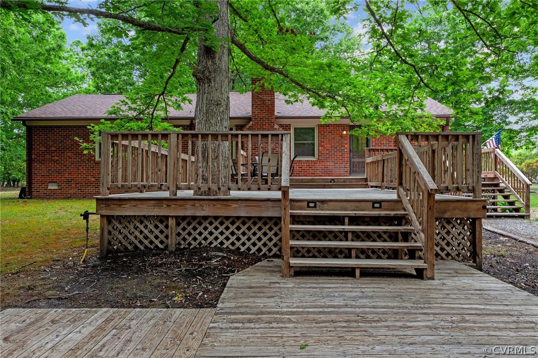 8601 Beaver Bridge Road Moseley, VA 23120 - Photo 31 of 42 a view of a deck with a table and chairs a barbeque with wooden floor and fence