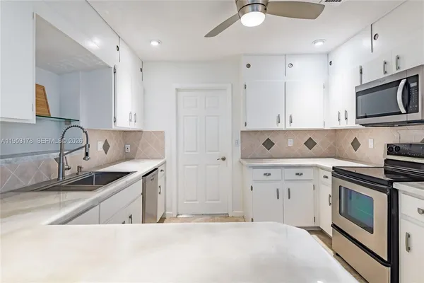a kitchen with stainless steel appliances granite countertop a sink and a stove