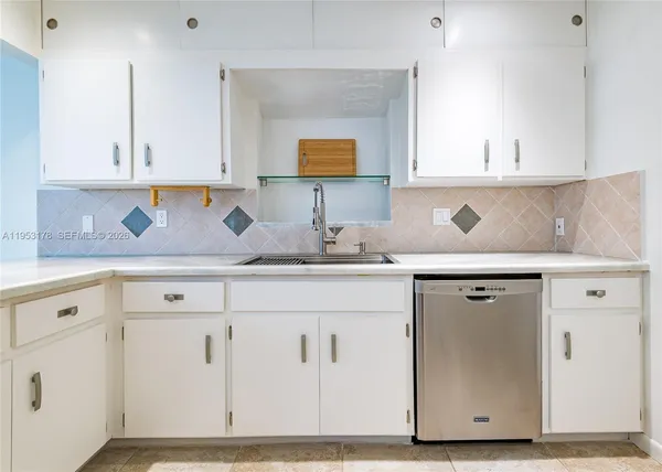 a kitchen with granite countertop a sink cabinets and stainless steel appliances