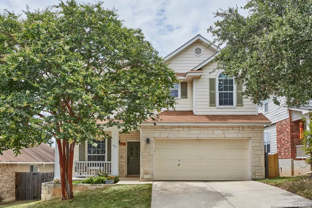 a front view of a house with a tree
