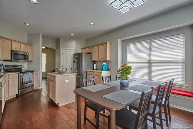 a kitchen with a table chairs refrigerator and microwave
