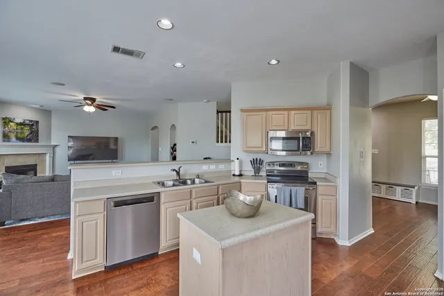 a kitchen with a sink dishwasher stove and oven with wooden floor