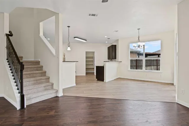 a view of a kitchen with wooden floor and staircase