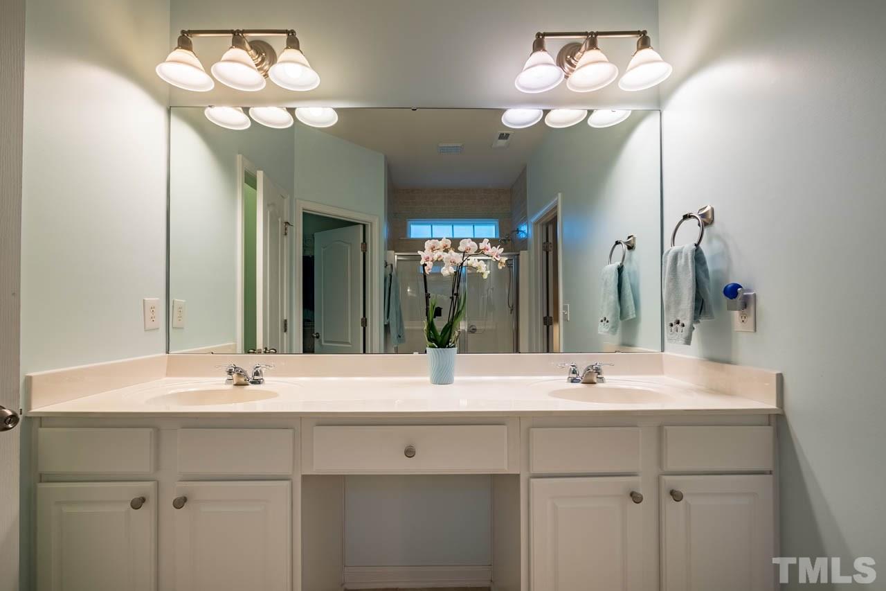 3400 Cathedral Bell Road Raleigh, NC 27614 - Photo 16 of 26 a bathroom with double vanity sinks a vanity a lamp and a mirror