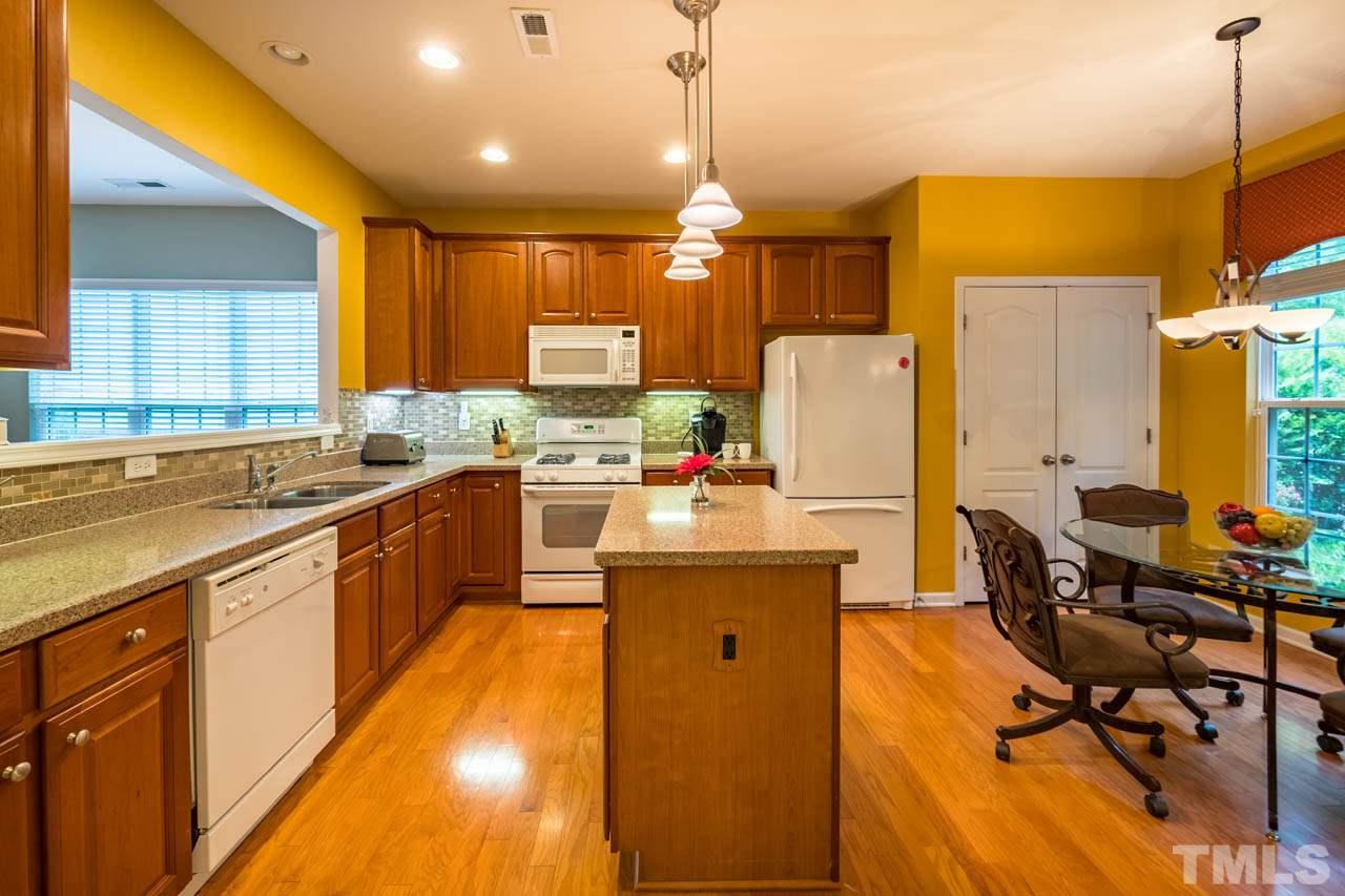 3400 Cathedral Bell Road Raleigh, NC 27614 - Photo 10 of 26 a kitchen with stainless steel appliances kitchen island granite countertop a sink a stove and a refrigerator