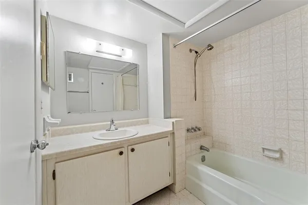 a bathroom with a tub sink shower and mirror