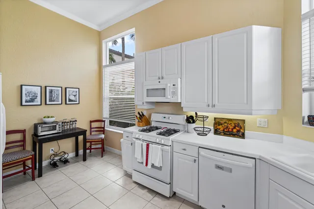 a kitchen with stainless steel appliances white cabinets and a window