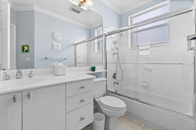 a bathroom with a double vanity sink toilet and shower