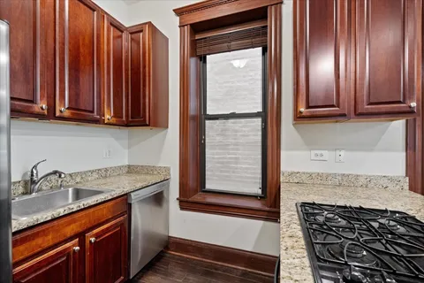 a kitchen with stainless steel appliances granite countertop wooden cabinets a sink and a stove