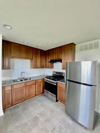 a kitchen with stainless steel appliances granite countertop a refrigerator sink and stove