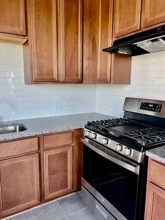 a kitchen with granite countertop a stove and a sink