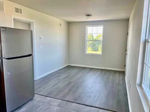 an empty room with wooden floor and a window