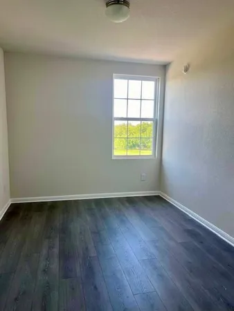 an empty room with wooden floor and a window