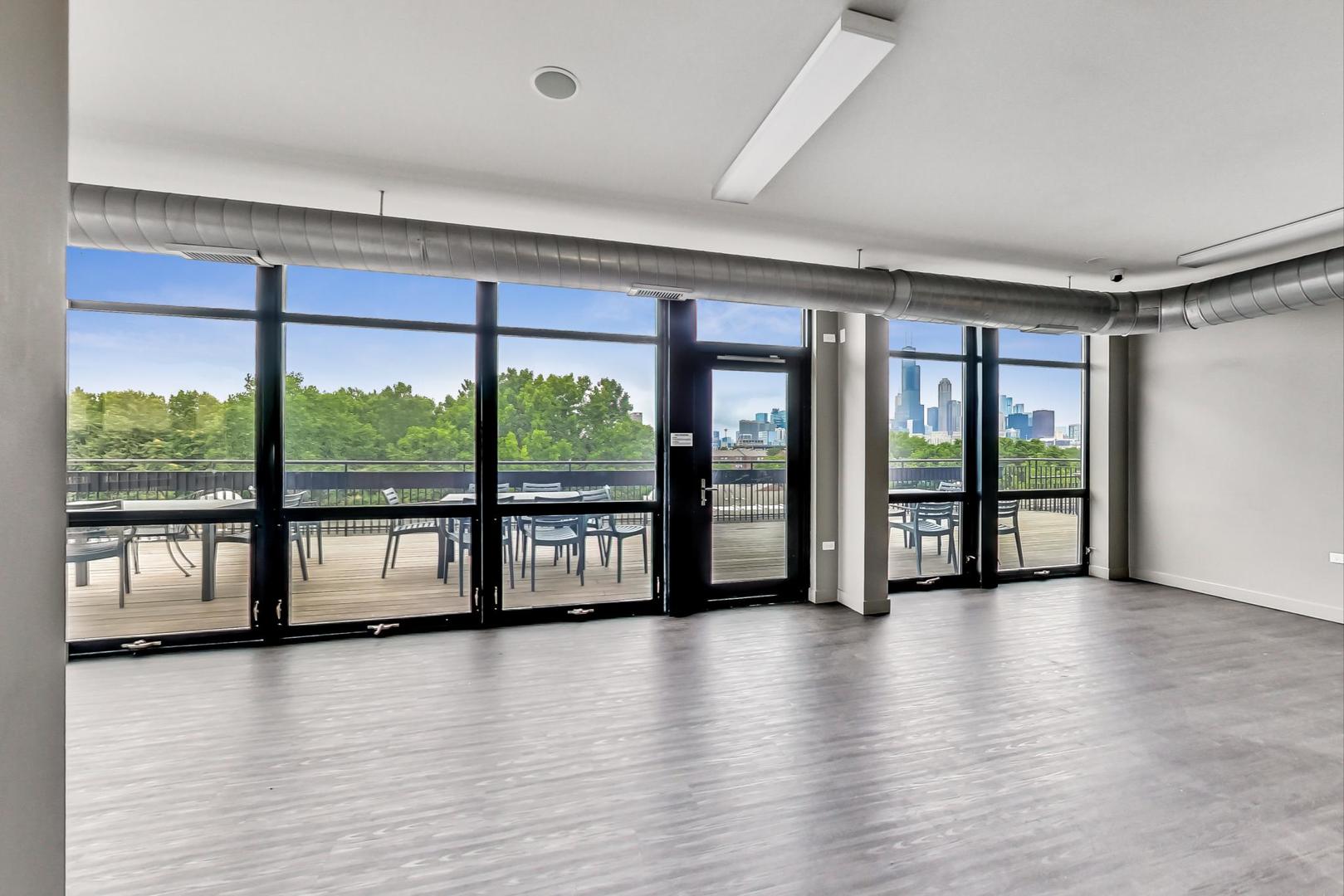 1151 West 14th Place, Unit 404 Chicago, IL 60608 - Photo 21 of 28 wooden floor in an empty room with a large window