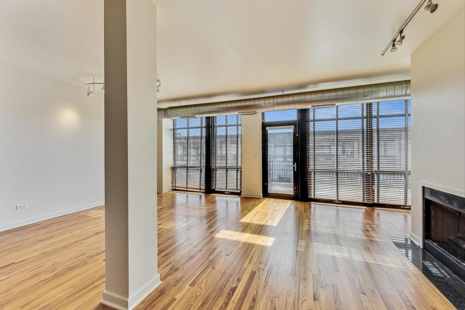1151 West 14th Place, Unit 404 Chicago, IL 60608 - Photo 3 of 28 a view of an empty room with wooden floor and a window