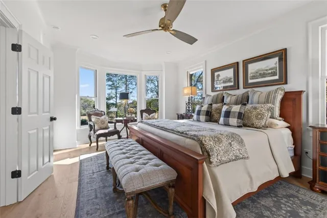 a spacious bedroom with a bed a chandelier and a dresser