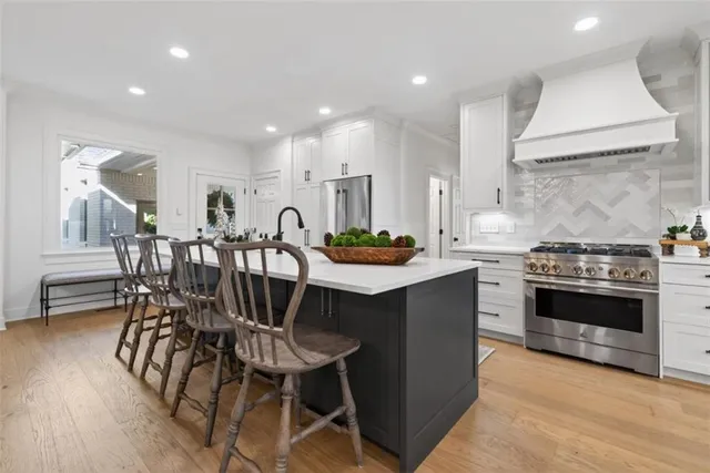 a kitchen with stainless steel appliances a table chairs stove and cabinets