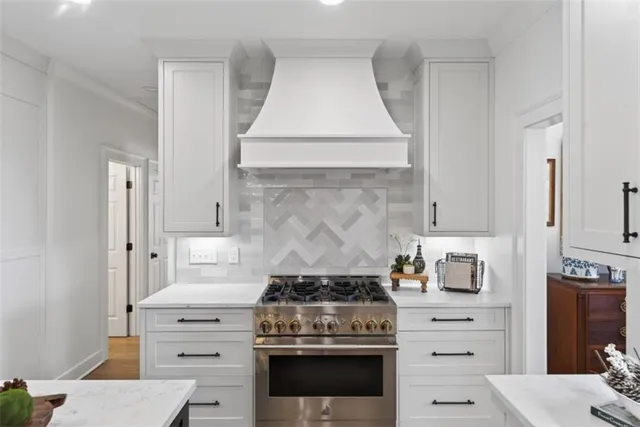 a kitchen with a stove and white cabinets
