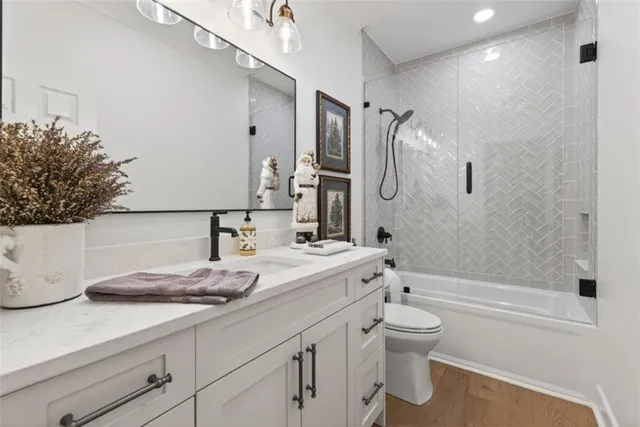 a bathroom with a granite countertop sink a toilet and shower