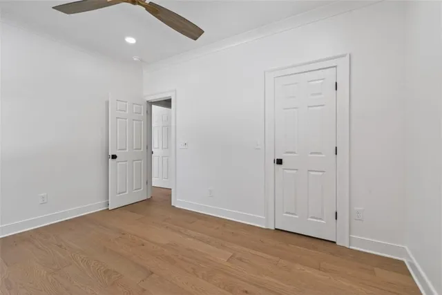 an empty room with wooden floor and closet area