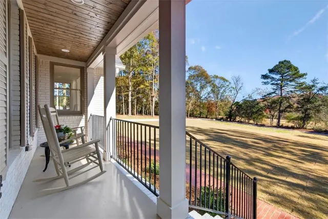 a view of a porch with furniture and floor to ceiling window