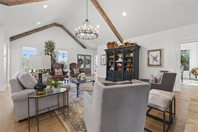 a living room with furniture a chandelier and a dining table