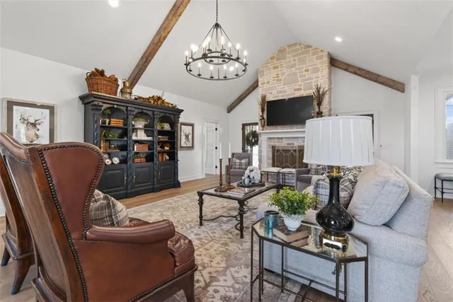 a living room with furniture a fireplace and a chandelier