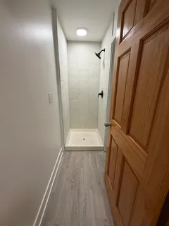 a view of bathroom with a shower and wooden floor