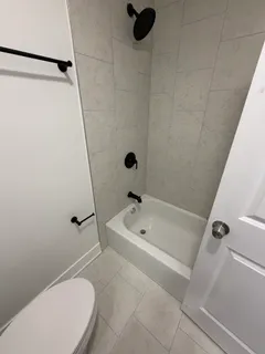 a bathroom with a bathtub a toilet and a shower