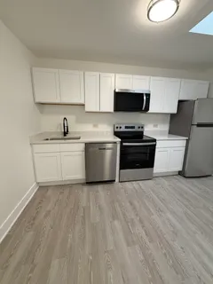 a kitchen with stainless steel appliances a stove top oven a sink a microwave and cabinets