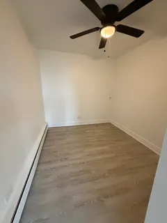 an empty room with a ceiling fan and carpet