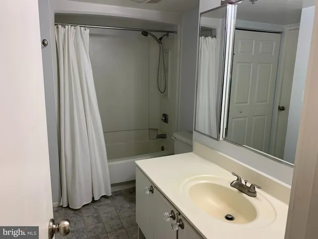 a bathroom with a granite countertop sink and shower