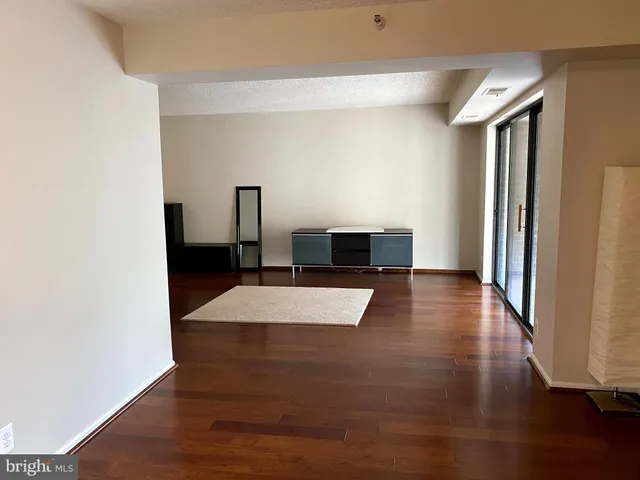 an empty room with wooden floor book shelf