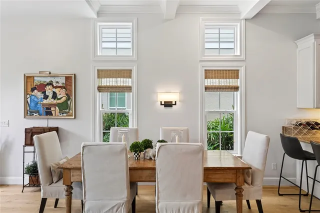 a kitchen with stainless steel appliances kitchen island granite countertop a stove top oven a sink dishwasher and white cabinets with wooden floor