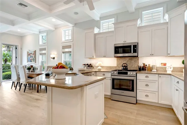 a kitchen that has a sink and a stove with white countertops