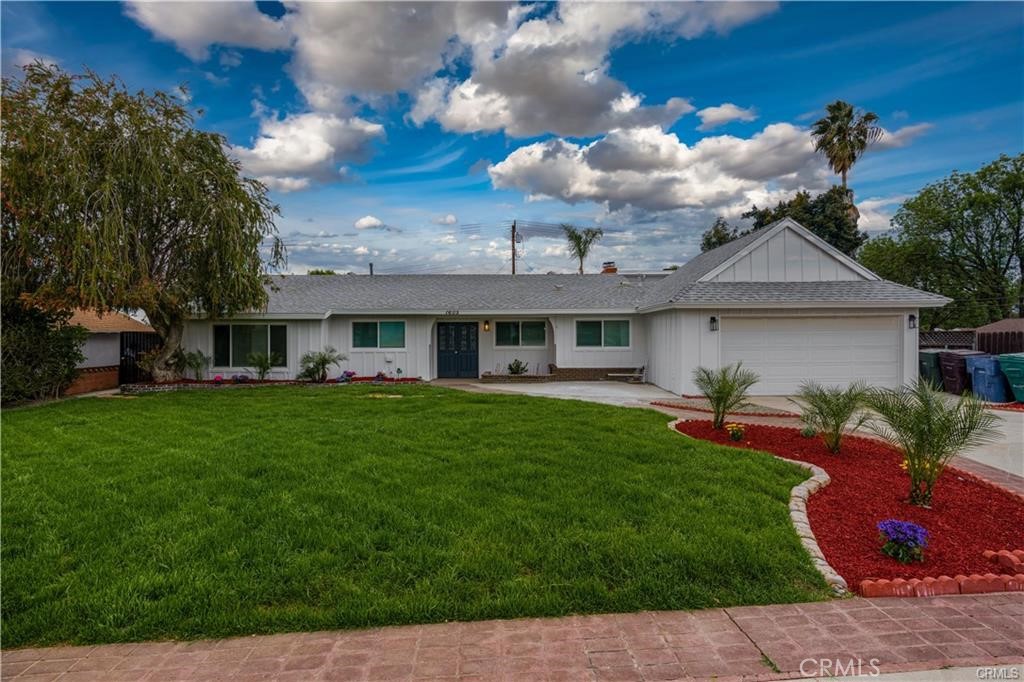 a front view of a house with a garden and yard