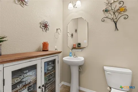 a bathroom with a toilet sink and mirror