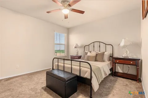 a bedroom with a bed and ceiling fan