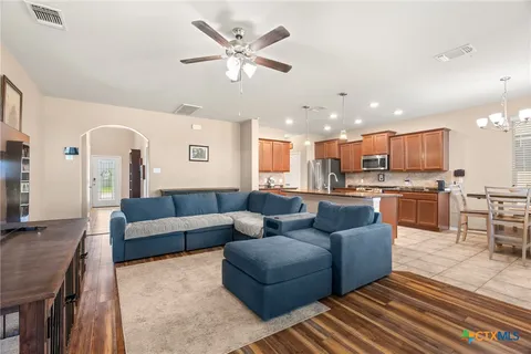 a view of kitchen with kitchen island stainless steel appliances wooden floor dining table and chairs