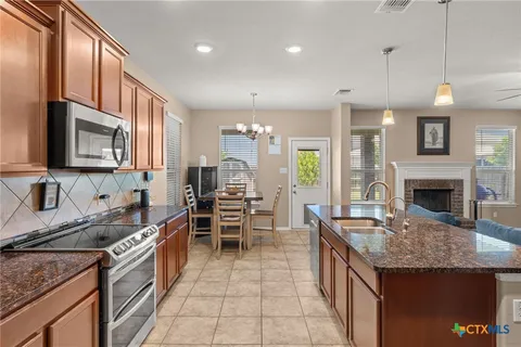 a kitchen with granite countertop kitchen island stainless steel appliances a sink stove and microwave
