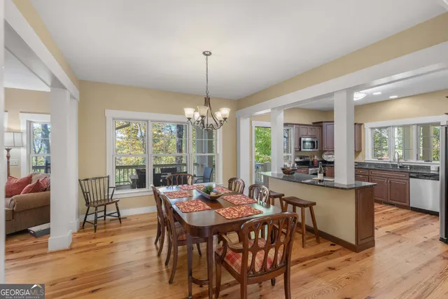 a kitchen with stainless steel appliances granite countertop a refrigerator a sink dishwasher a stove with wooden cabinets and floor