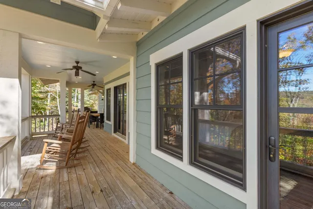a view of a patio with a table and chairs and floor to ceiling window next to a yard
