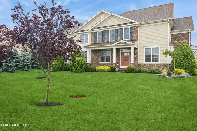 a front view of a house with a yard and trees