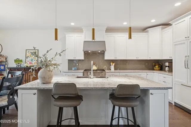 a kitchen with stainless steel appliances a sink a stove a refrigerator and cabinets